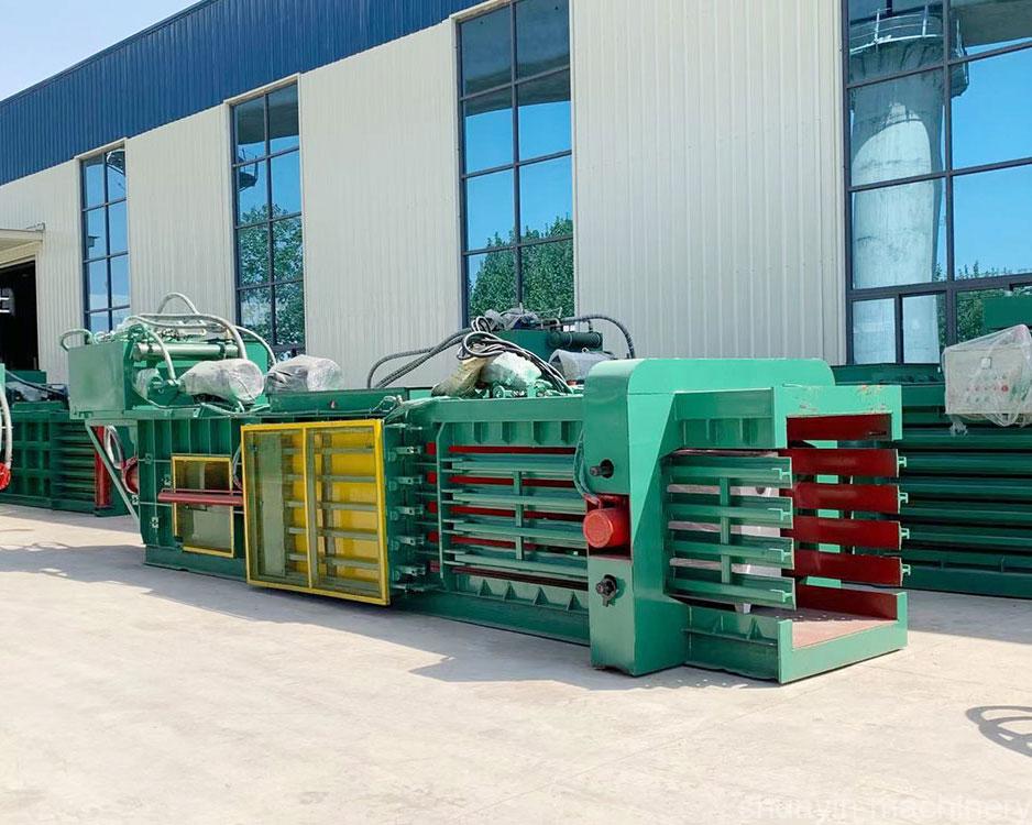 Horizontal baler for industrial-scale waste compaction and recycling.  