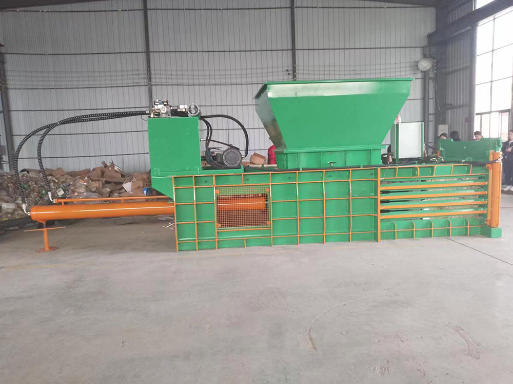 Cardboard baler with auto-tie feature for seamless recycling operations.