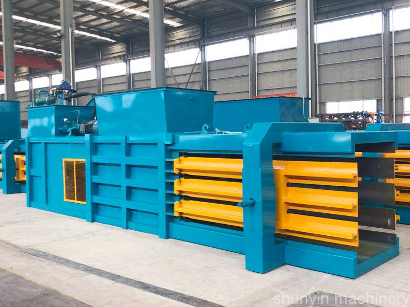 Horizontal hydraulic compactor for compressing and packaging various recyclable materials.