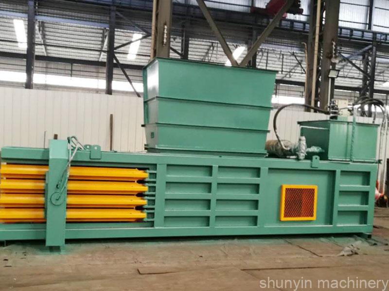 Closed-door horizontal baling machine for secure and efficient waste compaction.  