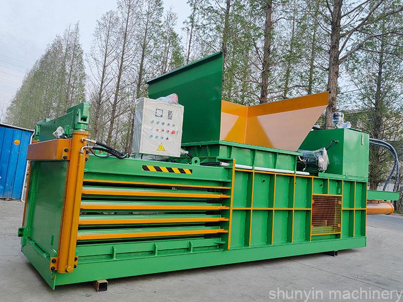 Reliable horizontal baler for industrial material recycling needs.