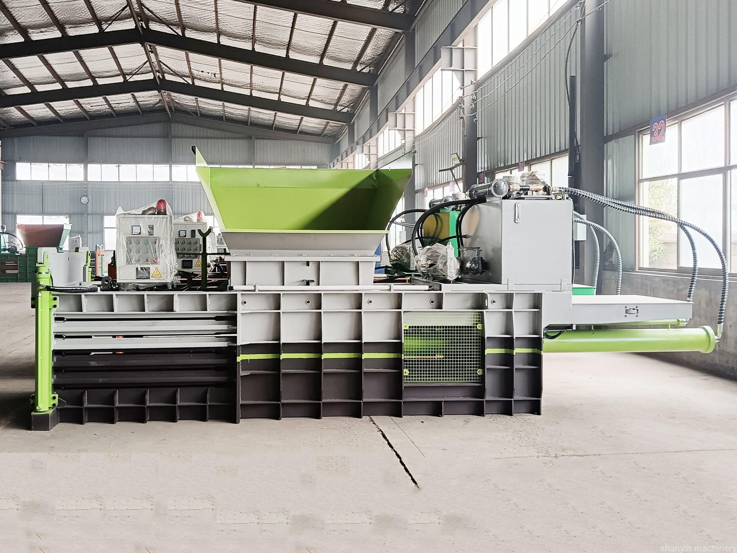 Horizontal baler for industrial-scale waste compaction and recycling.