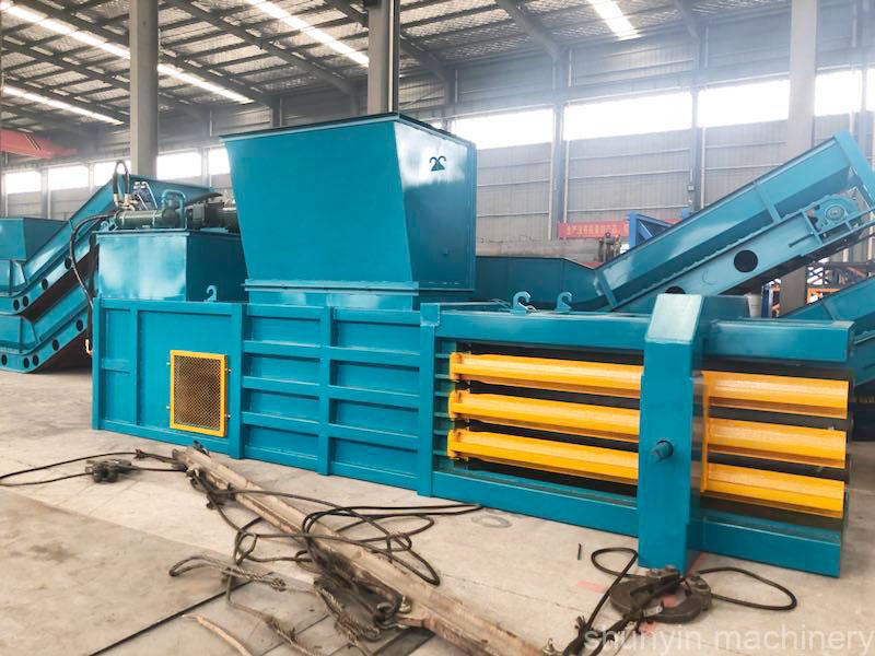 Horizontal hydraulic compaction machine for compacting and packaging materials