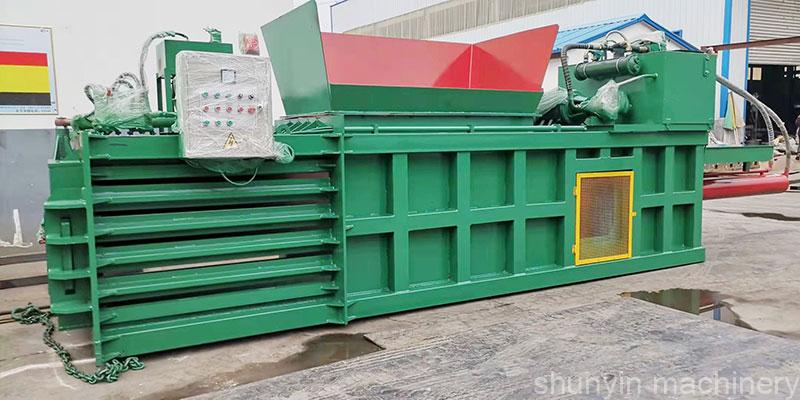 Horizontal baler for recycling waste materials with auto-tie feature