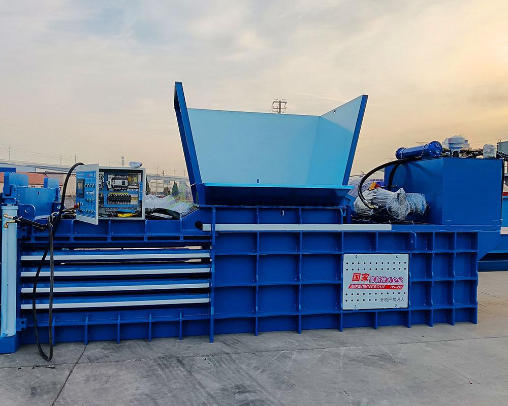 Robust horizontal baler for compressing scrap metal efficiently.