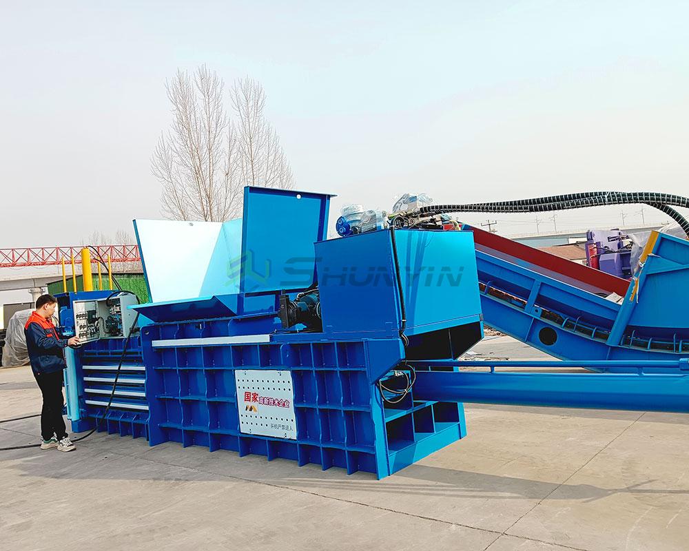 Horizontal baler for compacting waste materials into manageable bales for recycling.