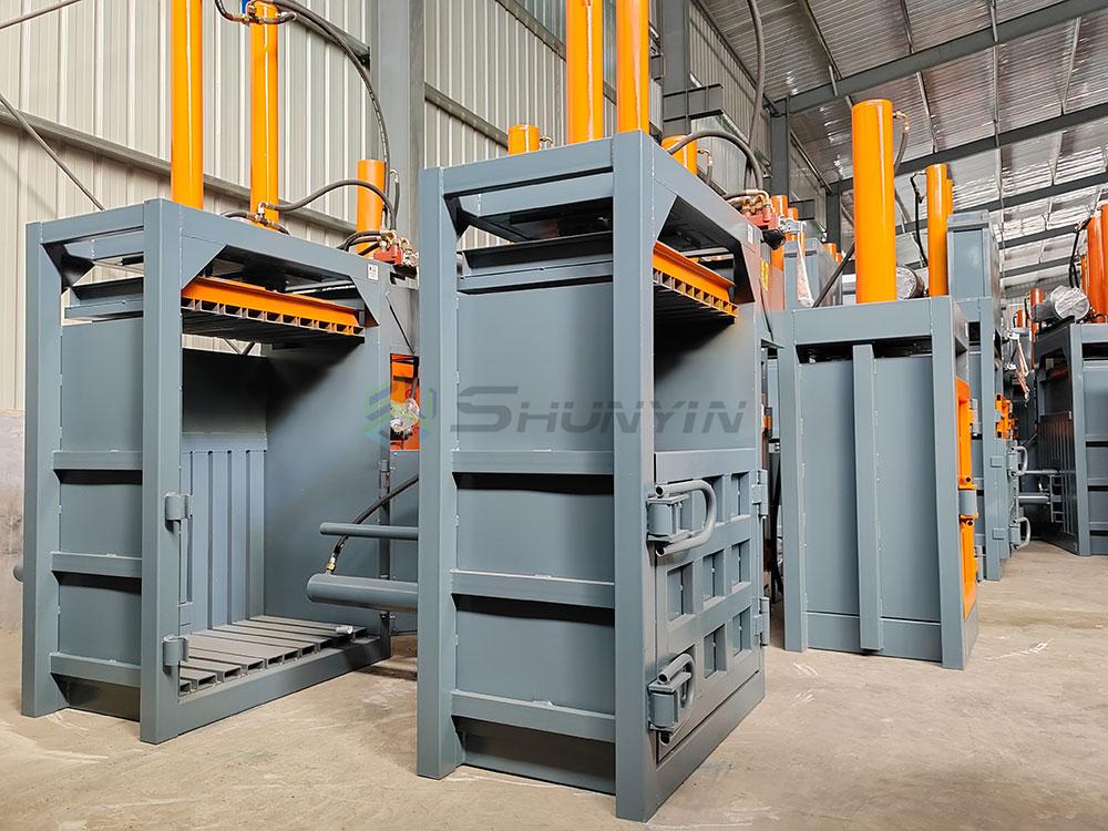 Scrap metal baler crushing car bodies