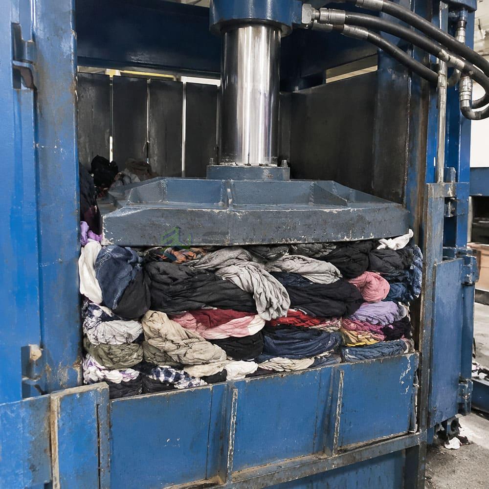 Hydraulic baler compressing textile waste